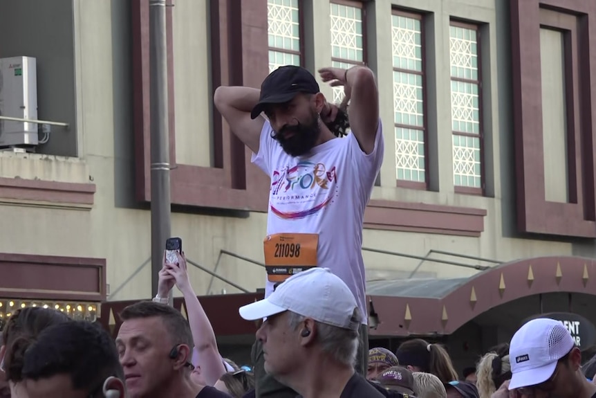 A man stands much taller than the crowd around him