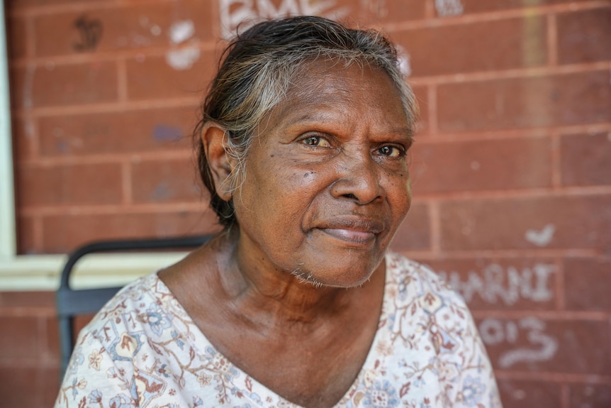 a woman looks sternly at the camera