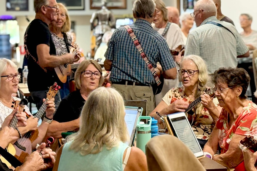 Women sitting around playing ukuleles.