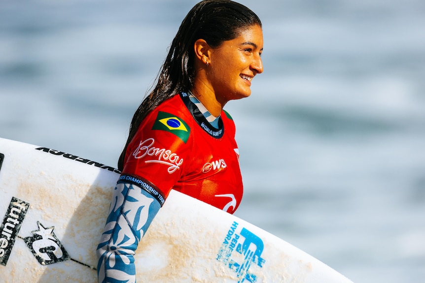Luana Silva holding a surf board at the 2025 Bells Beach competition.