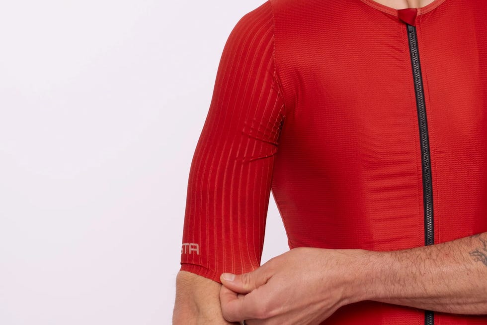 Athlete wearing a red fitted sports shirt with short sleeves and a front zipper. Athlete wearing a red fitted sports shirt with short sleeves and a front zipper.