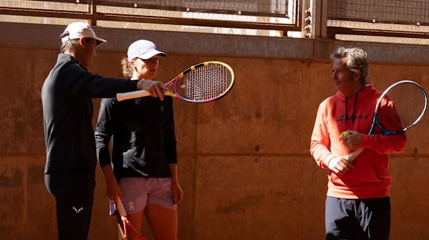 Rafael Nadal speaks with Iga Swiatek during a training session.