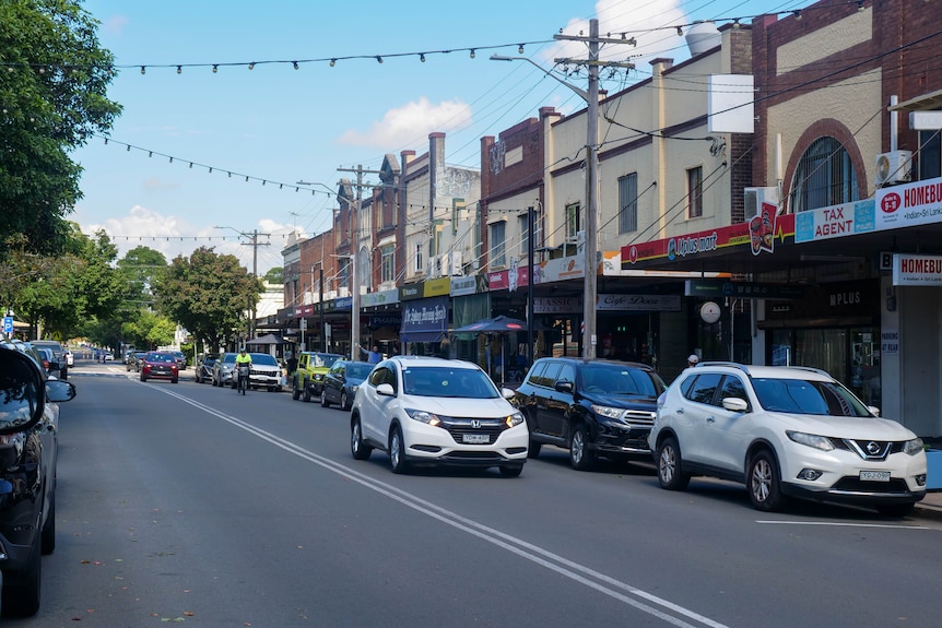 a row of shops with cars driving through