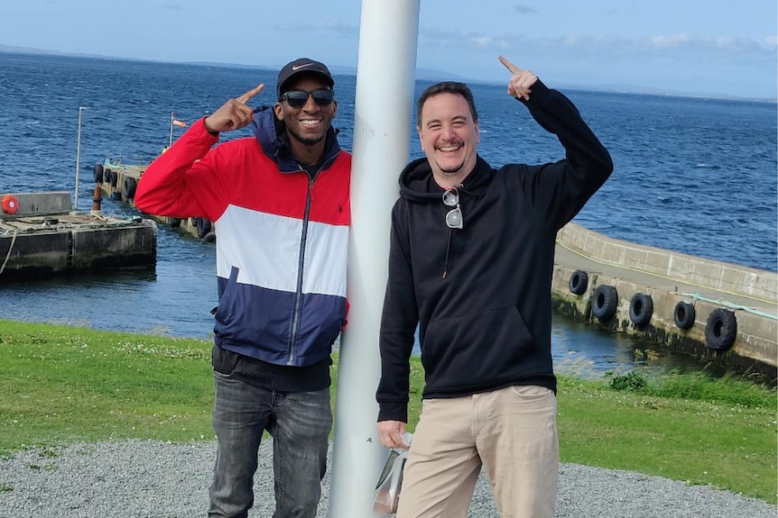 Eric Smith and his partner Warren pose in front of the ocean