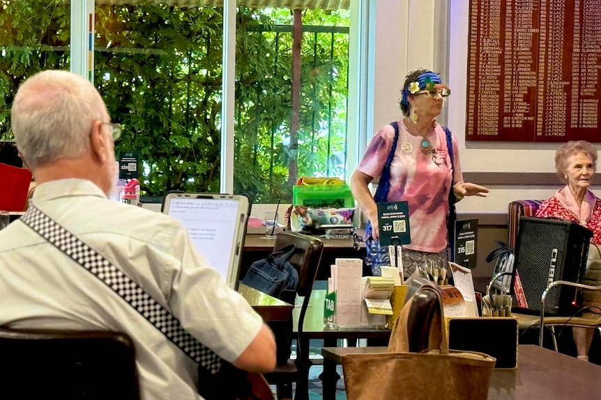 A man playing a ukulele as two women listen.