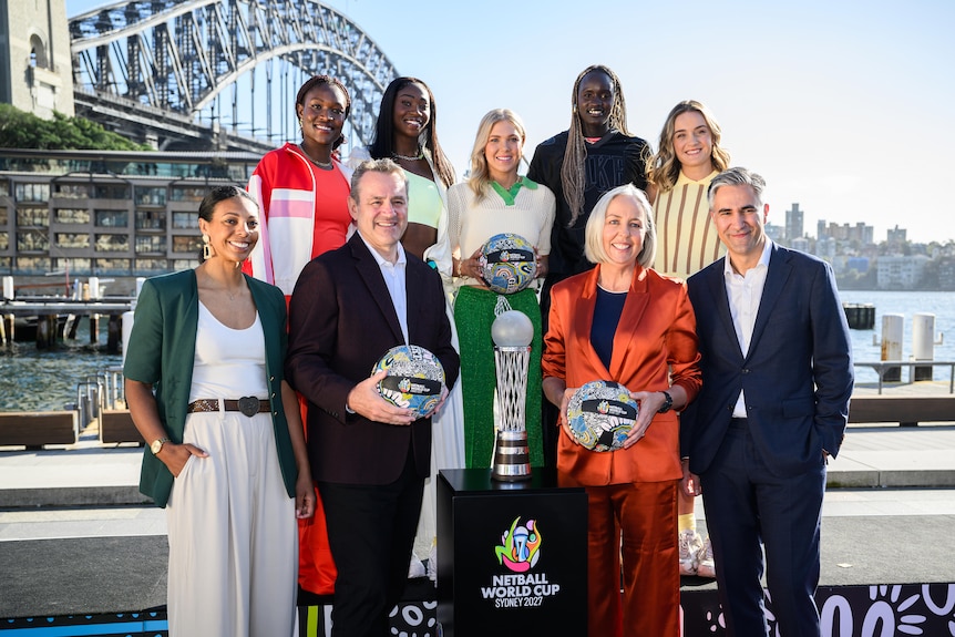 Netball adminstrators and players pose with the Netball World Cup trophy in Sydney Harbour
