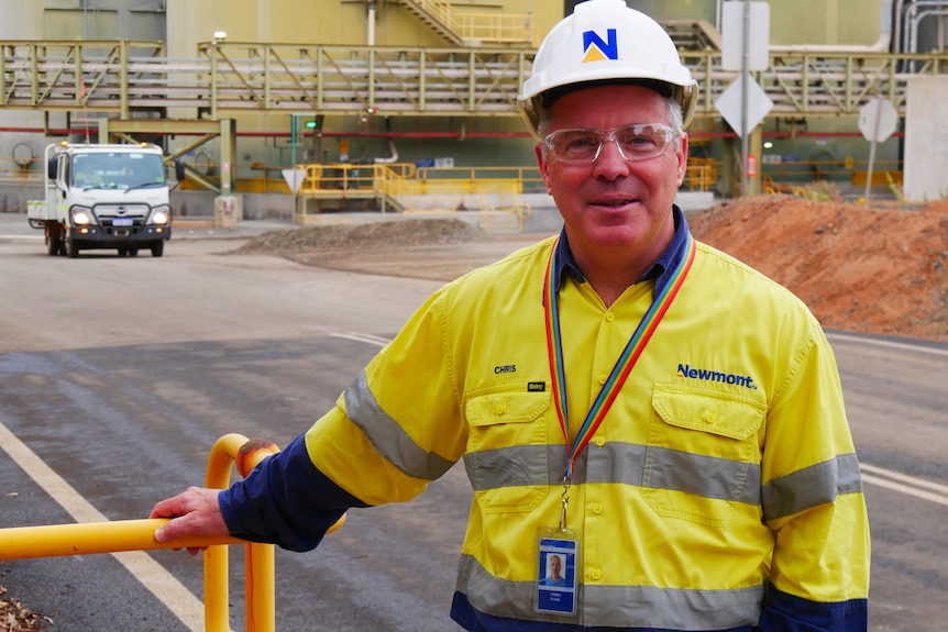 Chris Dark standing at the mine wearing hi vis clothing and a hard hat