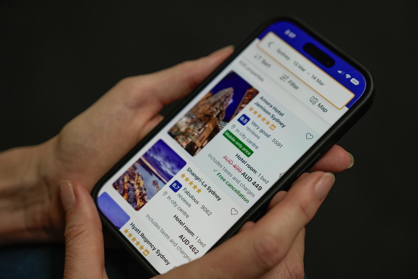 Close up of an iphone looking at accommodation on booking.com