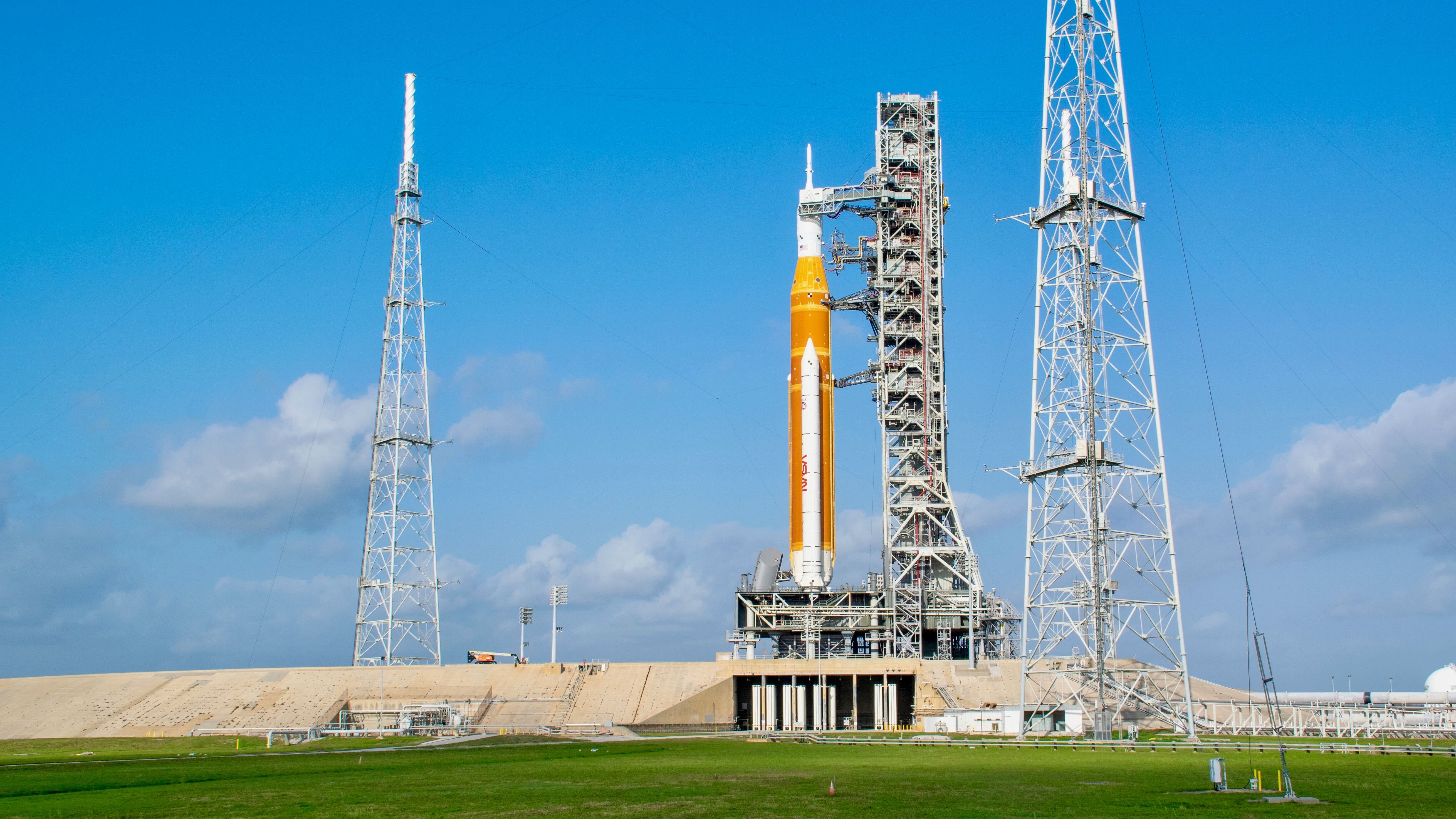 An orange rocket on the launchpad.