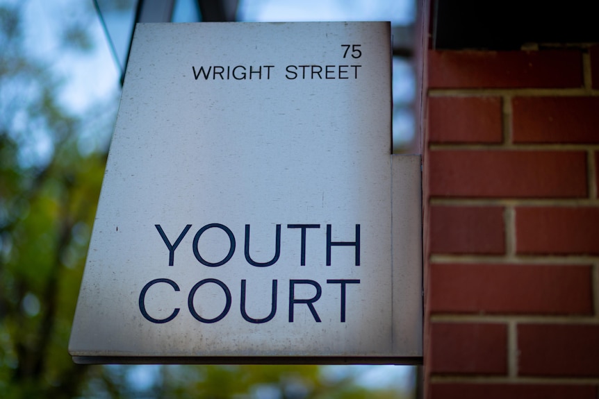 A sign that says "Youth Court" is affixed to a brick building.