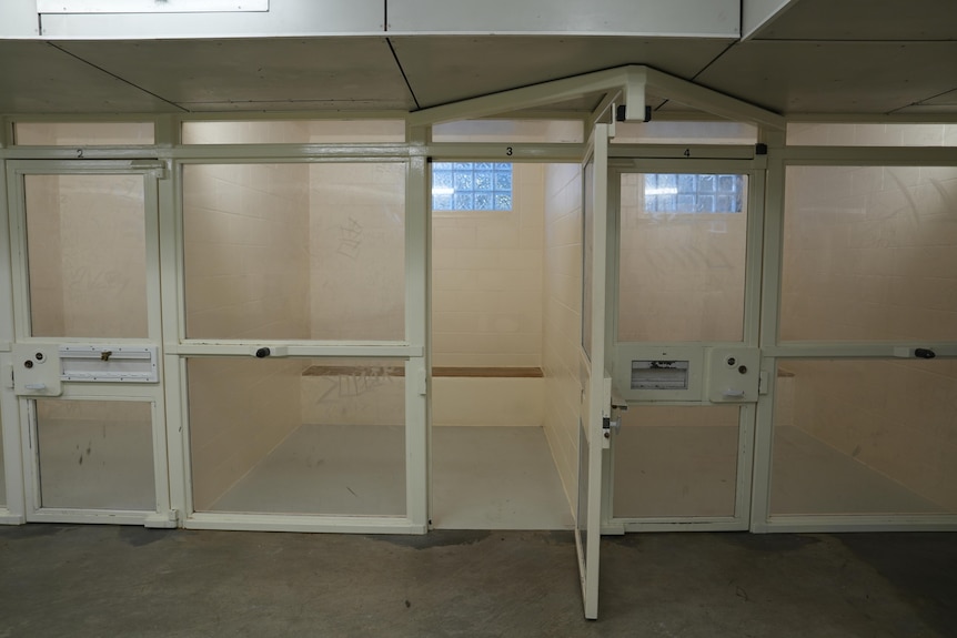 Three small cells next to each other with persplex glass walls. One door is opened