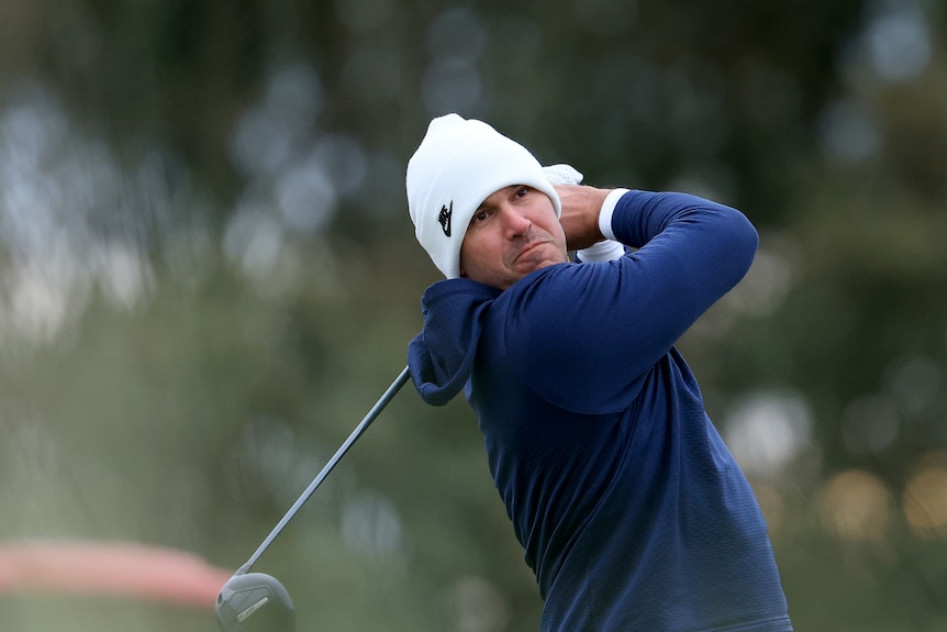 Brooks Koekpa swings his golf club