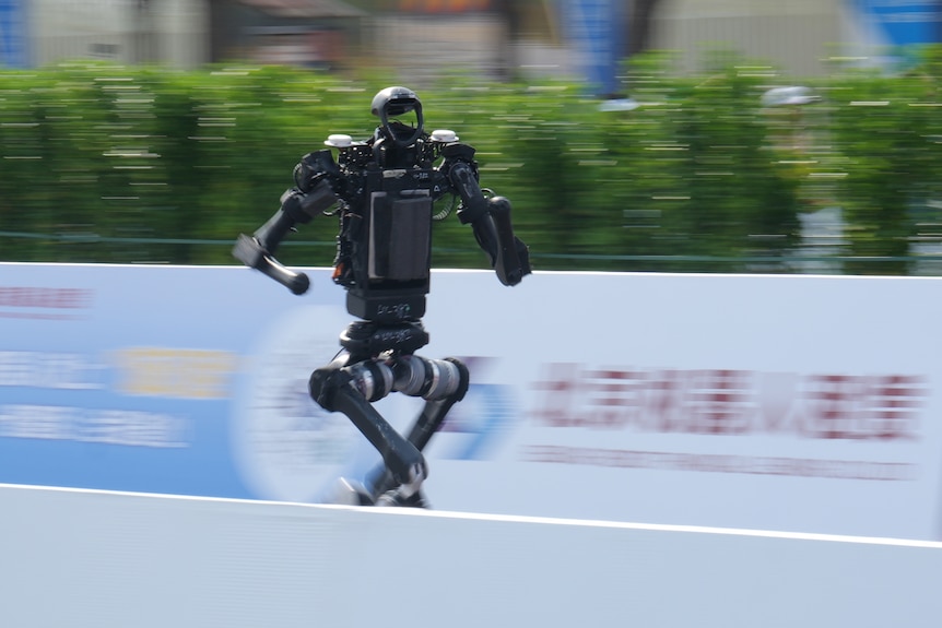 A black robot runs. 