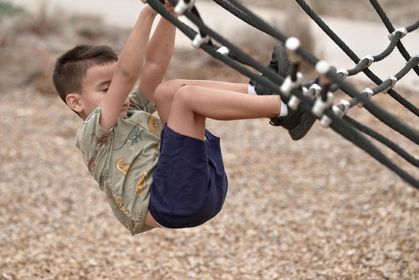 A young boy playing in a public playground