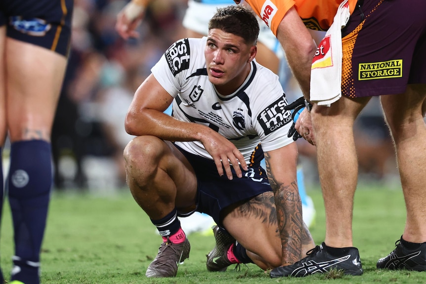 Reece Walsh crouches down after sustaining a facial injury against the Gold Coast Tians in the NRL.