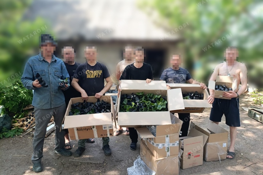 Volunteers hold boxes of the 3D parts they have printed to help the Ukrainian military