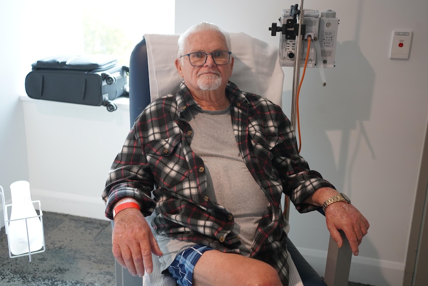 A man looks at the camera with a serious expression.