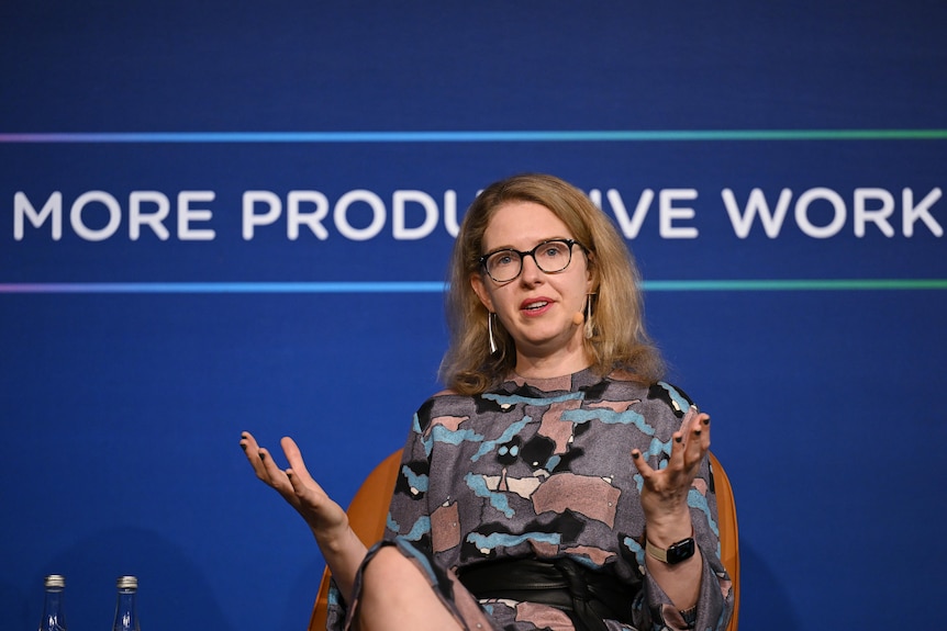 Danielle Wood sits speaking gesturing with her hands.