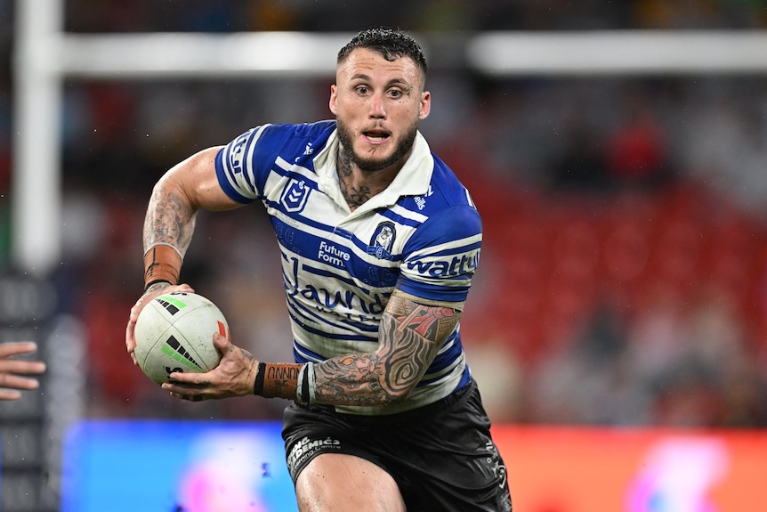 Bronson Xerri running with the ball in two hands during and NRL match