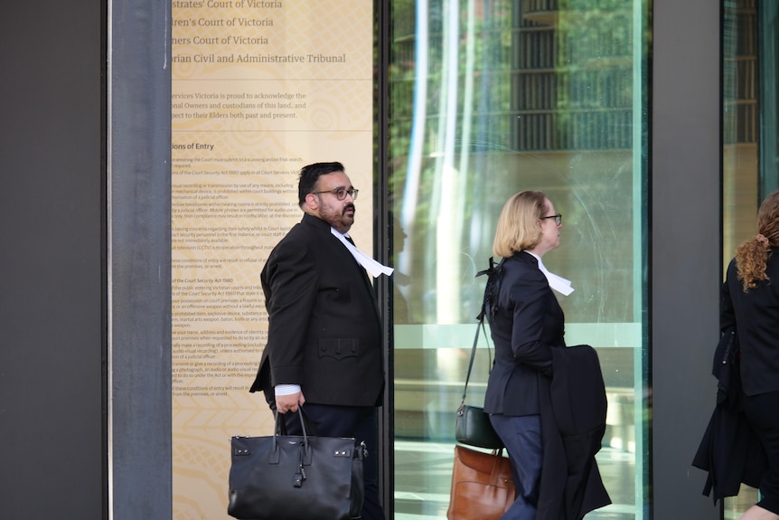 A group of lawyers enters a court room. 