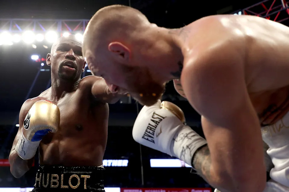 LAS VEGAS, NV - AUGUST 26:  (L-R) Floyd Mayweather Jr. throws a punch at Conor McGregor during their super welterweight boxing match on August 26, 2017 at T-Mobile Arena in Las Vegas, Nevada.  (Photo by Christian Petersen/Getty Images)