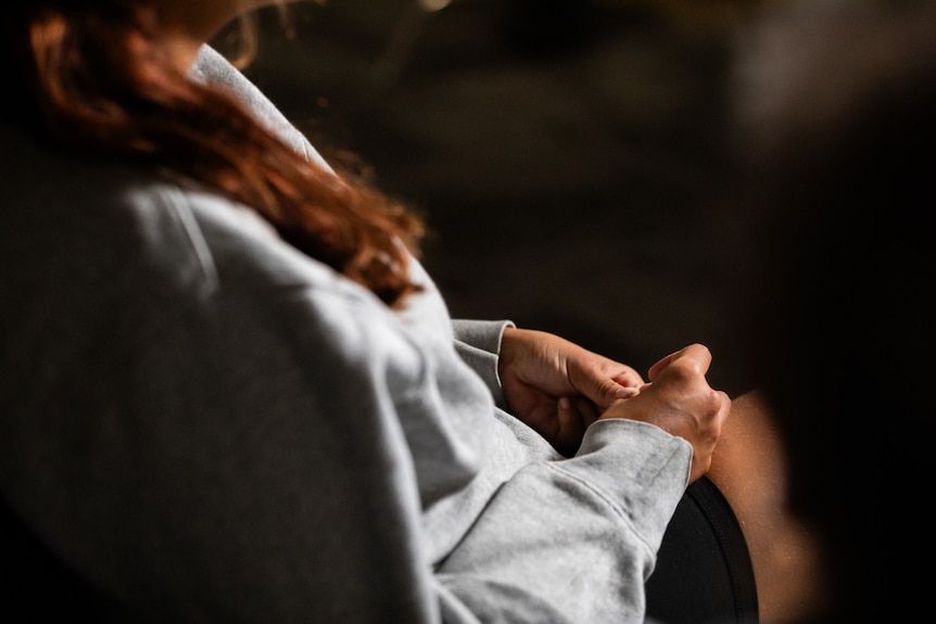 A photo of a girl in a grey sweatshirt 
