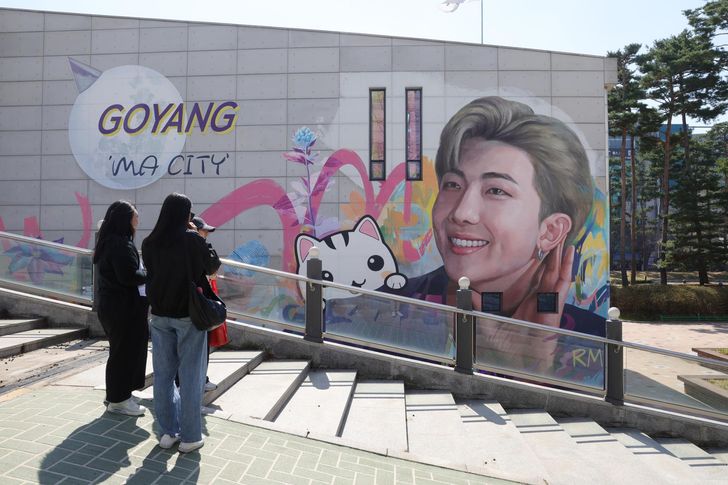 Fans take a look at a mural of BTS' leader RM at Ilsan Culture Square in Goyang, Gyeonggi Province, Wednesday, a day before the start of BTS' world tour 'ARIRANG' that begins in Goyang, Thursday. RM's hometown is Goyang. Yonhap