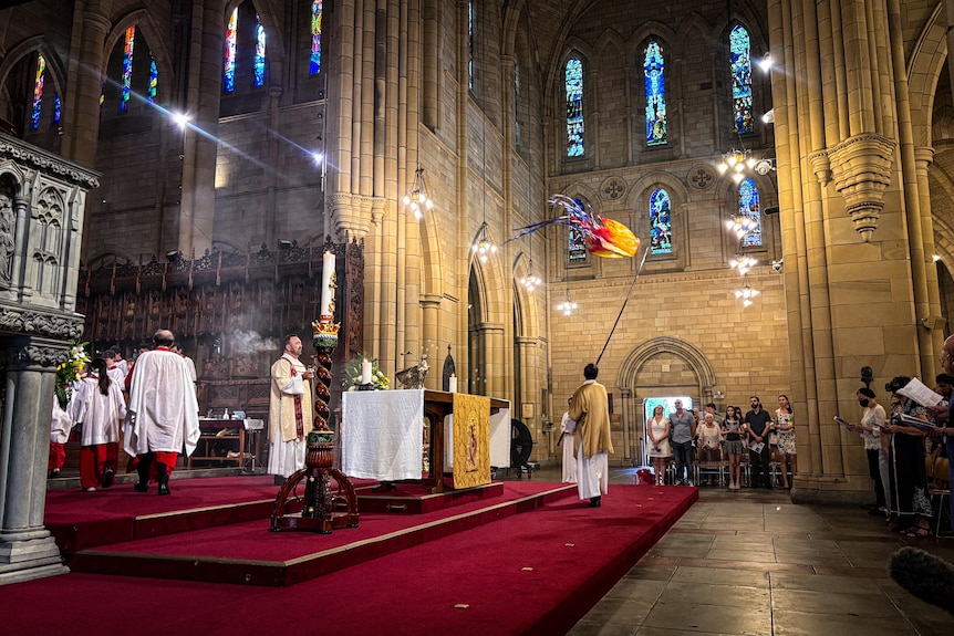 A church service in a large and ornate stone building.