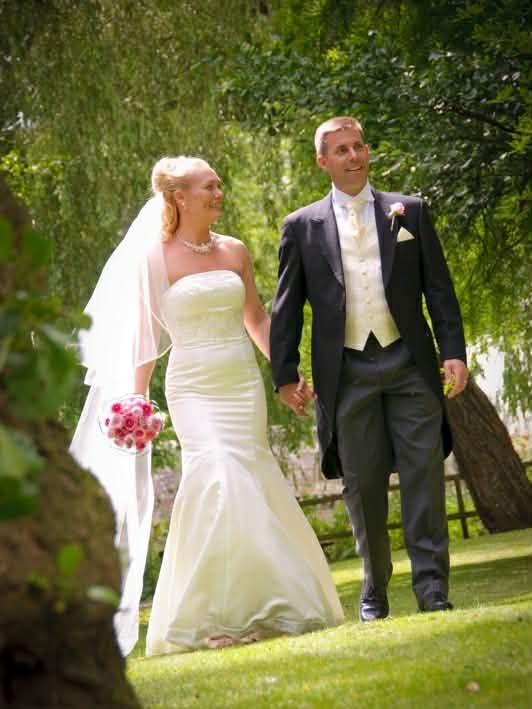 A man and woman on their wedding day looking very happy