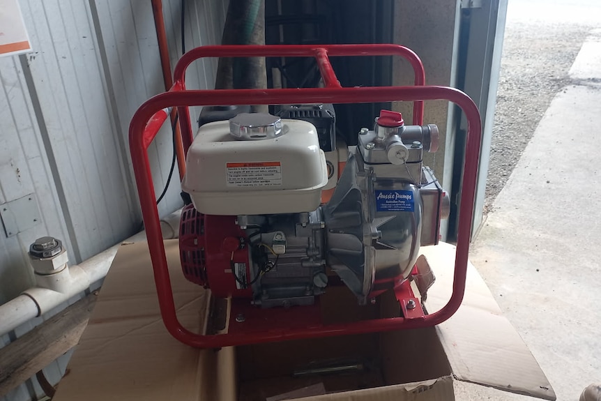 A water pump sits inside a rural fire station shed.