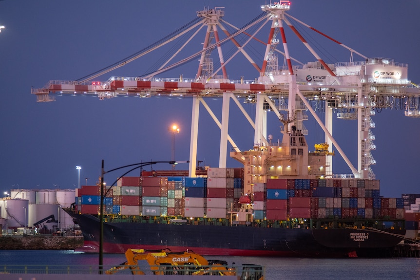 Ships on water in harbour loaded with containers.