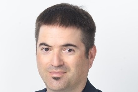 a close up of a man with dark brown hair, eyes and moustache.