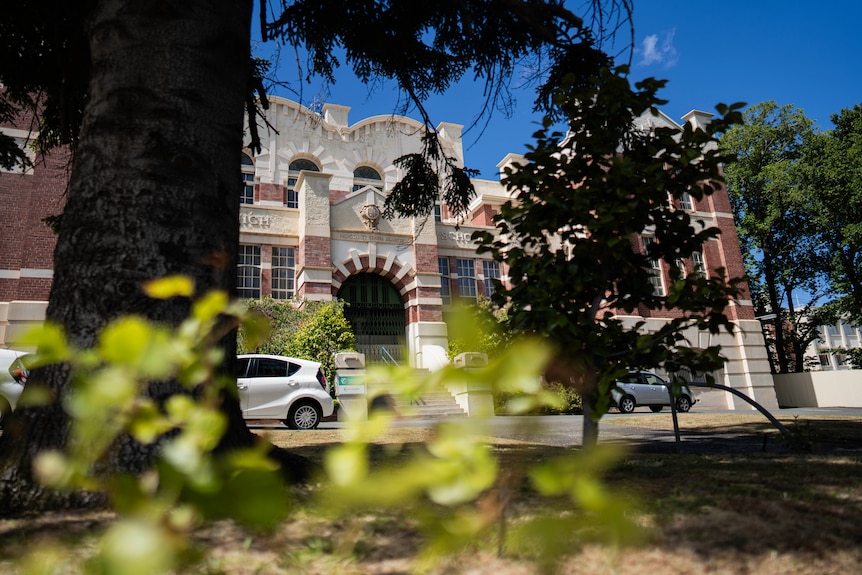 Old school building in white and brown sandstone.
