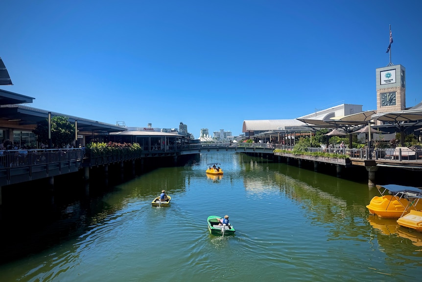 Boats in a canal through a shopping complex.