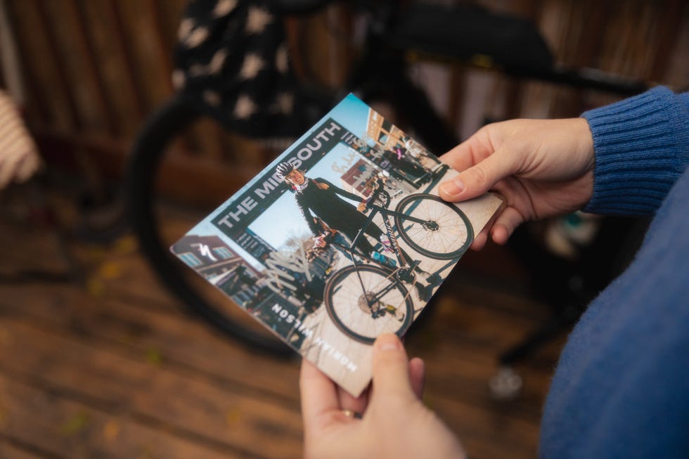 a person holding a photo of a cyclist