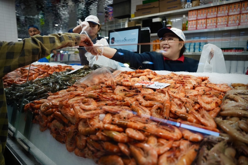 A woman selling prawns at the Sydney Fish Market 