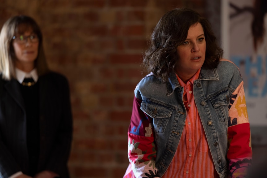Kitty Flanagan stands out of focus in the background with Anne Edmonds, right, looking frustrated.