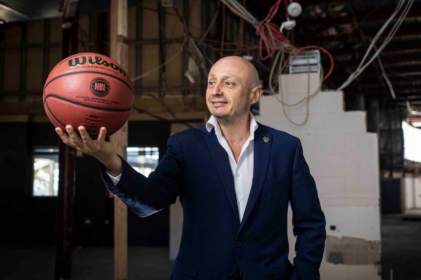 A balding man looks at a basektball