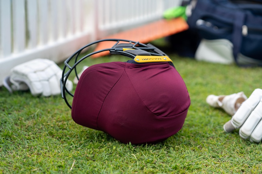A purple cricket helmet lying on its side