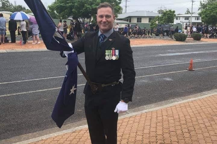 An image of Glenn David Lee holding the Australian flag.