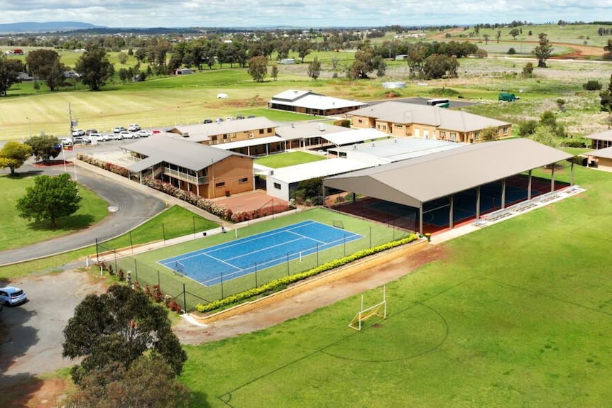 drone shot of school grounds with tennis court