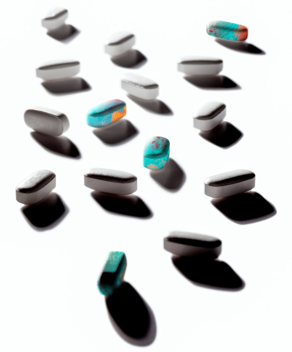 Assorted pills scattered on a white surface.