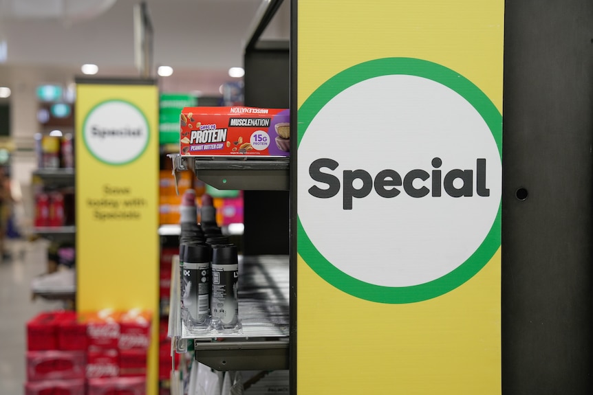 A green and yellow sign with the words special in black on a white background, with another sign in the background.