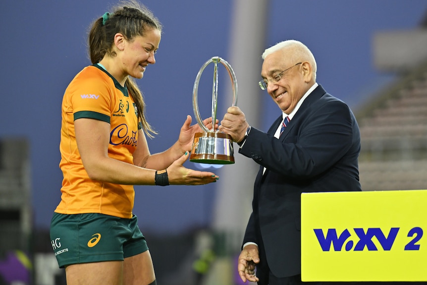Michaela Leonard of Australia is handed the WXV 2 trophy in 2024.