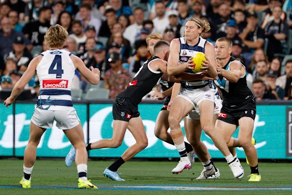 Mark Blicavs of the Cats is tackled by Ollie Wines of the Power.