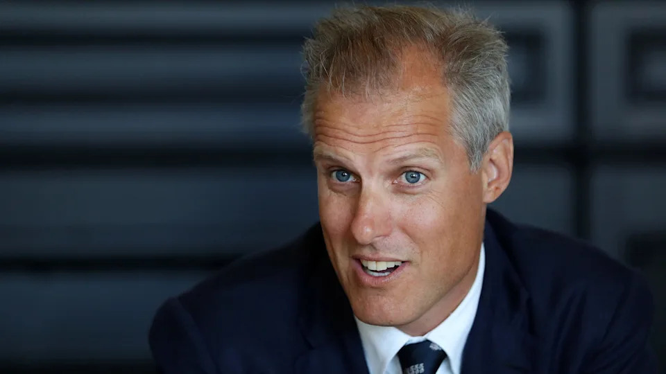 Ed Smith, during his time as national selector. He has short greying hair, blue eyes and is wearing a blue blazer and tie over a white shirt.