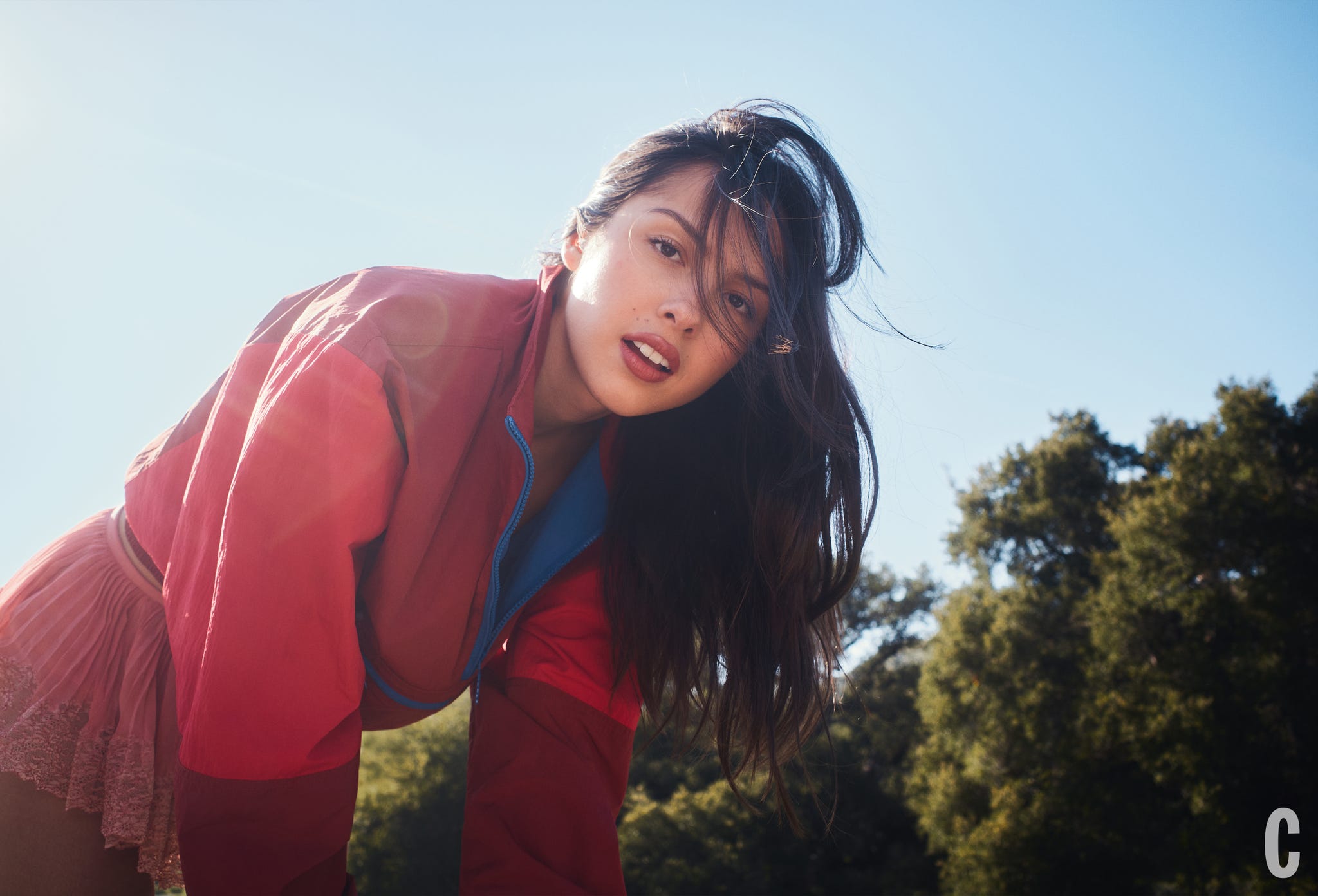 Person in a colorful outfit bending forward outdoors. Person in a colorful outfit bending forward outdoors.