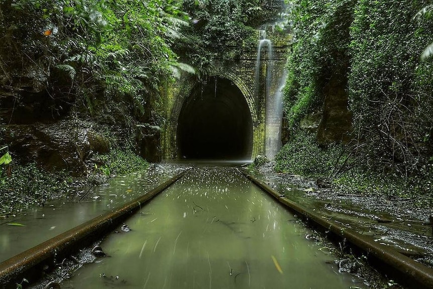A railway line through a tunnel covered in water.