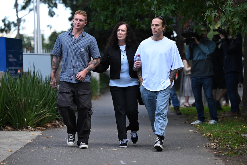 Three people on sidewalk