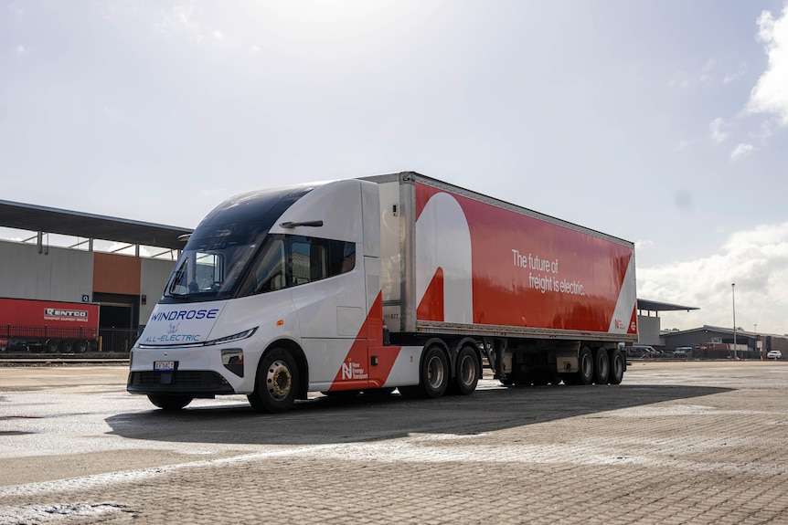 A red and white truck in an industrial background.